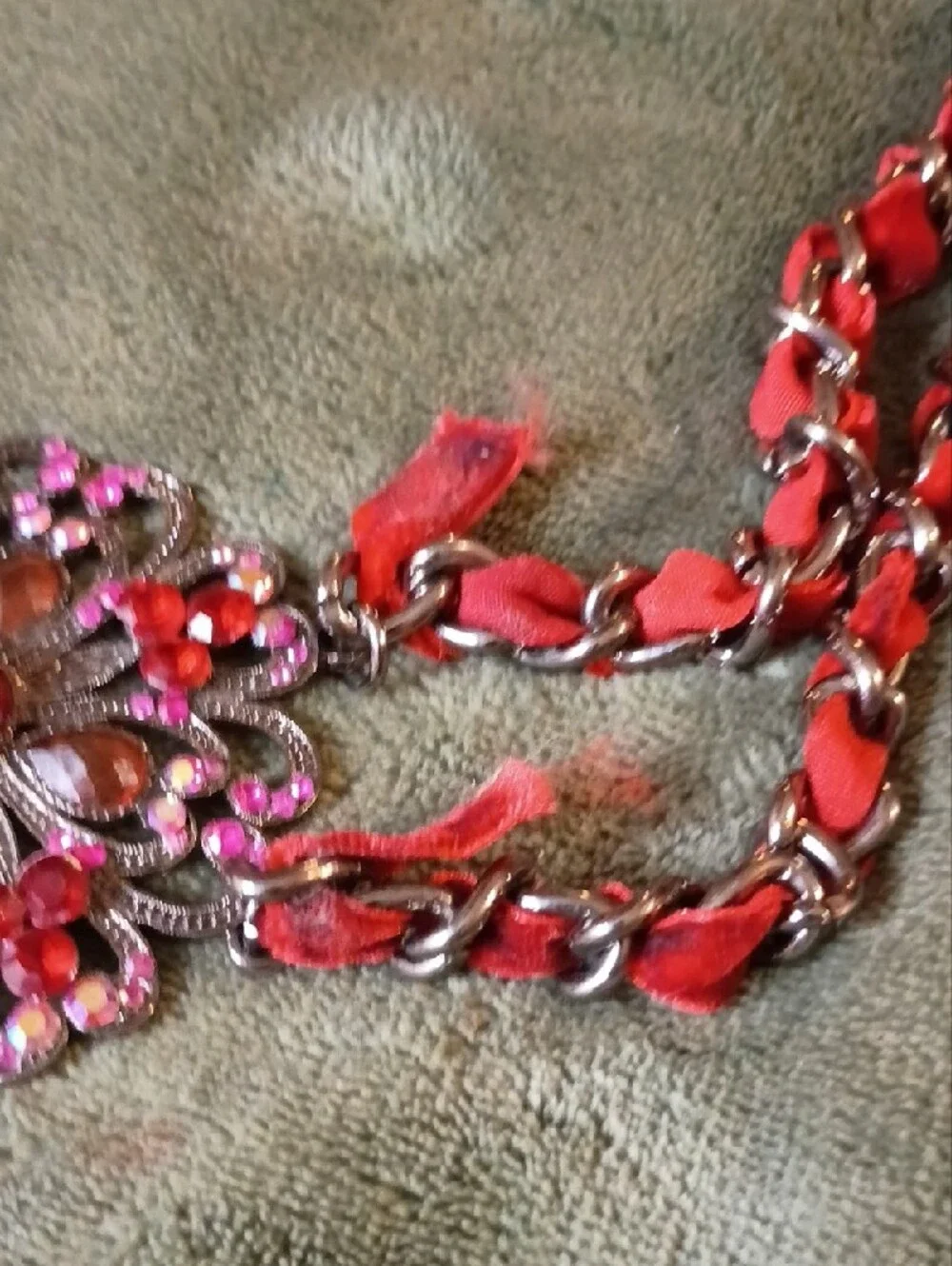 Multi Strand Necklace Featuring Interwoven Ribbon Centered Around Ornate Floral